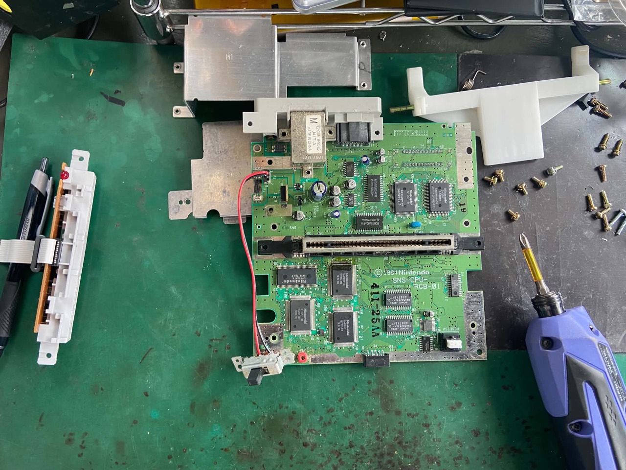1994年製スーパーファミコンの基板を分解して点検する様子